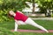 Smiling girl in the park exercise on the yoga mat, high lunge