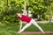 Smiling girl in the park exercise on the yoga mat, high lunge