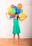 Smiling girl playing with inflating balloons