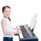 Smiling girl plays on the electric piano.