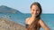 Smiling girl portrait on sea beach. Happy child posing on camera at vacations