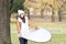 Smiling girl posing at camera with the reflector, outdoor.