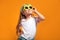 Smiling girl posing in the funny sunglasses and looking away on yellow background