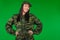 Smiling girl, professional soldier posing on green background with blank space for your advertisment