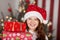 Smiling girl in a Santa hat with her gifts