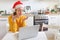 Smiling girl in Santa hat sending air kiss video calling family by webcam. Woman with laptop having virtual meeting chat on