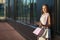 Smiling girl with shopping bags with phone in hand. Shopper. Sales