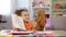 Smiling girl showing drawings teddy bear, playroom leisure, imaginary friend