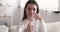 Smiling girl showing glass of water and thumbs up gesture.