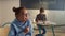 Smiling girl sitting at desk in classroom. Pupil raising hand during lesson