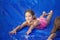 Smiling girl sliding down an outdoor slip and slide