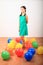 Smiling girl standing among inflating balloons