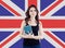 Smiling girl on the UK flag background. Pretty cheerful woman learning english language and traveling in United Kingdom