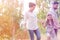 Smiling girl walking with parents against trees on field