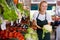 Smiling girl who works part-time in a store as a trainee saleswoman demonstrates cauliflower