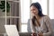 Smiling girl in wireless headphones working at laptop