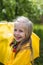 Smiling girl in a yellow dress with an umbrella on a rainy spring sunny day