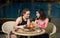 Smiling girlfriends eating breakfast with fruits and juice