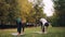 Smiling girls yoga teacher and student are exercising outdoors on grass in park practising asanas on mats with green and