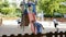 Smiling glad kids in school age sliding down together on playground's construction outdoors