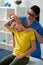 Smiling good-looking nurse supporting little girl during special exercises