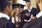 Smiling graduates with diploma scrolls near university