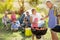 Smiling granddaughter baking barbecue with grandfather