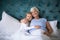 Smiling granddaughter and grandmother sitting together on bed