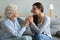 Smiling granddaughter holding grandmother hands, expressing love and support