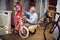 Smiling grandfather and girl choosing bicycle and helmets in bike shop