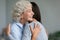 Smiling grandmother embracing granddaughter, enjoying tender moment, greeting