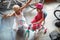 Smiling grandmother and girl choosing bicycle and helmets in bike shop