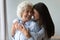 Smiling grandmother and granddaughter hugging, enjoying tender moment