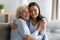 Smiling grandmother and granddaughter hugging, enjoying time together