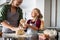 Smiling grandmother and happy child kneading dough