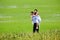 Smiling groom carrying on his back bride infield