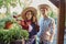 Smiling guy and girl gardeners in a straw hats are standing next