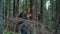 Smiling guy trekking woods in summer time. Happy traveler hiking in green forest