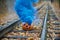 Smiling halloween pumpkin with bright blue smoke on the rails in the forest