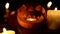 Smiling Halloween pumpkin in candlelight shines at night as a looped lantern