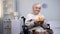 Smiling handicapped grandmother holding birthday cake in hands, hospital care