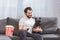 smiling handsome loner sitting with bulldog on sofa in living