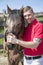 Smiling, handsome Male Horse Rider standing next to horse