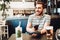 Smiling handsome man paying at restaurant using mobile pay technology, nfc modern payment system