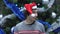 Smiling Handsome Man Wearing Santa Hat Saying No by Shaking Head on Christmas Tree Background.