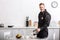 smiling handsome policeman pouring filtered coffee from glass pot