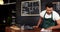 Smiling handsome waiter cleaning counter