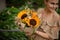 smiling handsome woman holds bouquet with lovely bright sunflowers in her hands.