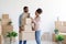 Smiling handsome young black couple unpack boxes of stuff in new apartment, enjoy moving