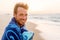 Smiling handsome young man beauty portrait on beach at sunset looking at camera laughing, healthy grin face of happy model in